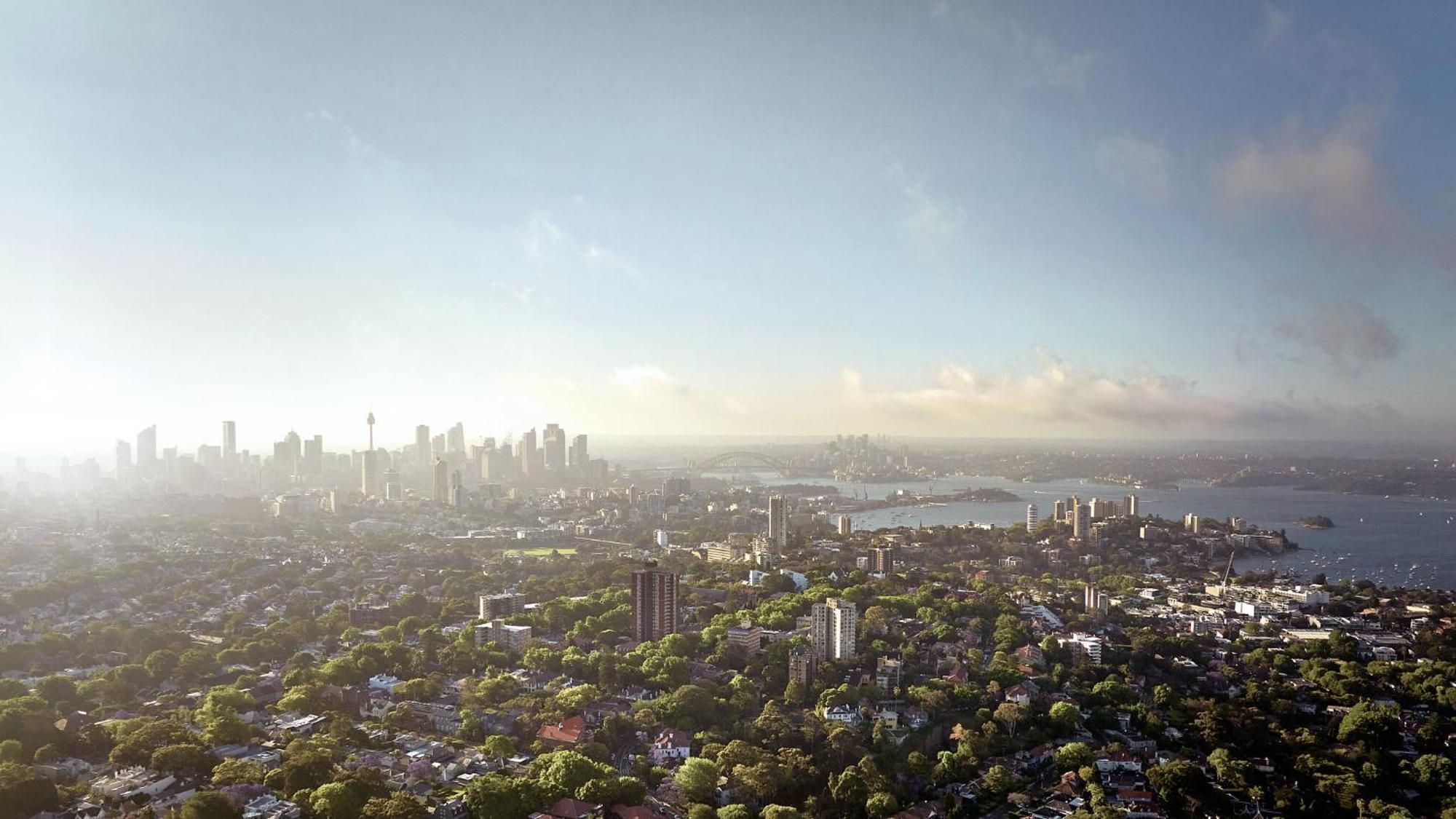 Meriton Suites Bondi Junction Sydney Exterior foto The photo shows a panoramic view of a city skyline, likely taken from a high vantage point. In the foreground, there are lush green trees and buildings, suggesting a suburban area. As the view extends towards the background, tall skyscrapers dominate